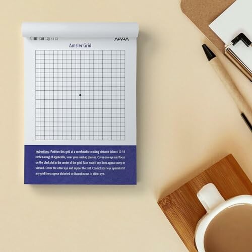 Amsler grid eye test on a notepad with pen and coffee.